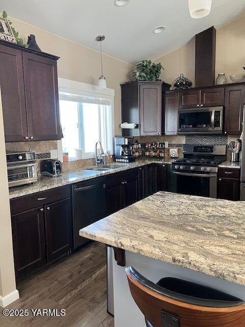 522 Adobe Way, Selah, WA 98942 - kitchen with appliances with stainless steel finishes, dark wood-style floors, decorative backsplash, light stone countertops, and hanging light fixtures