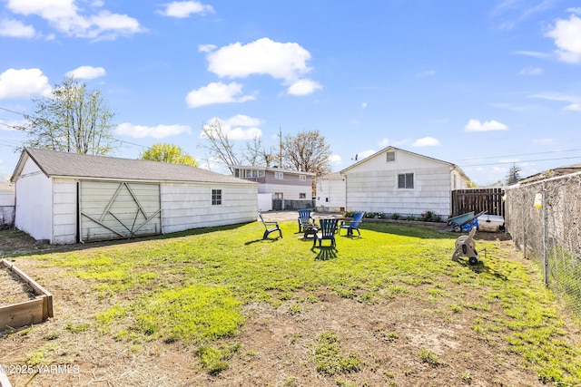view of yard featuring a fenced backyard, an outbuilding, and a garden