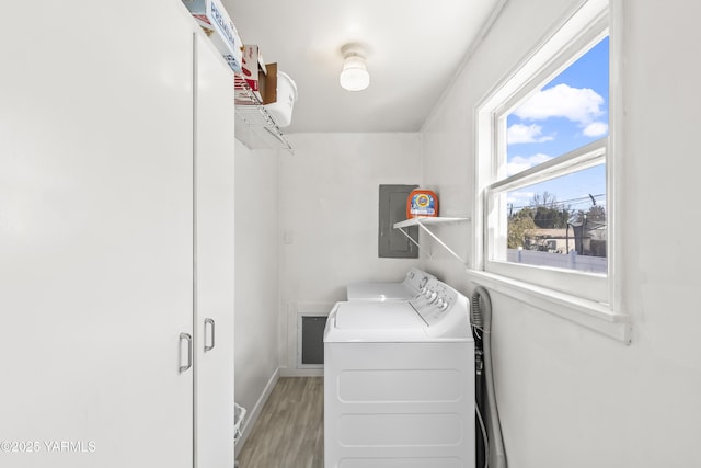 laundry room with laundry area, independent washer and dryer, electric panel, baseboards, and light wood-style flooring