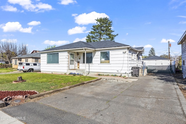 bungalow featuring a front lawn and fence