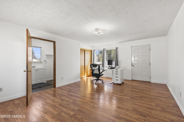 home office with wood finished floors, a textured ceiling, and baseboards