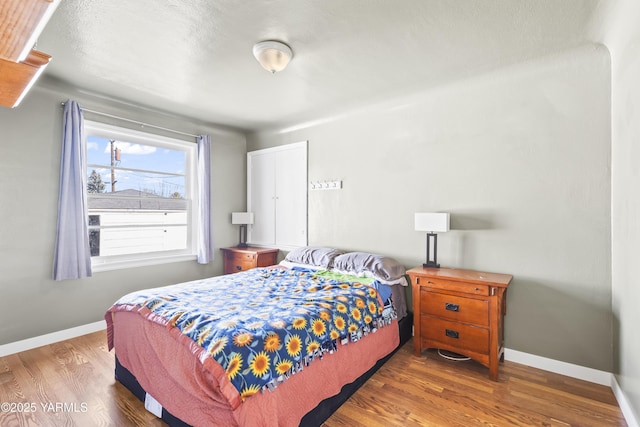 bedroom with baseboards and wood finished floors