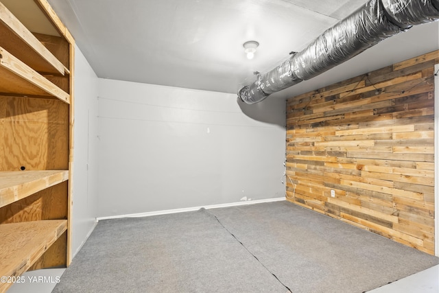 below grade area with wood walls and carpet floors