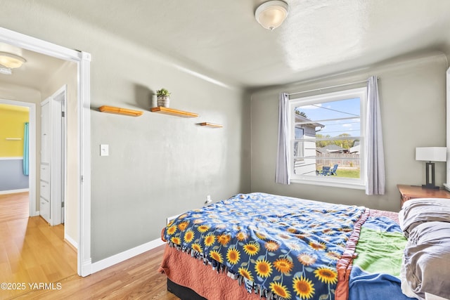 bedroom featuring baseboards and light wood-style floors
