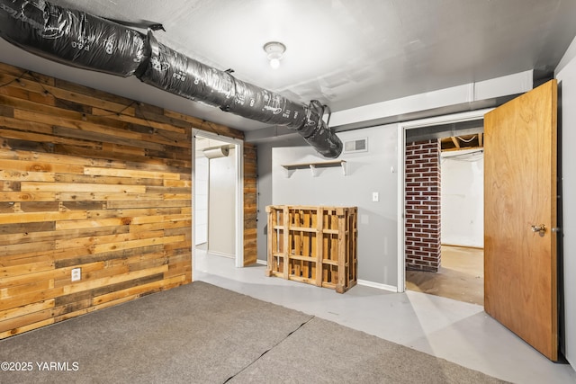 finished basement with wooden walls and visible vents