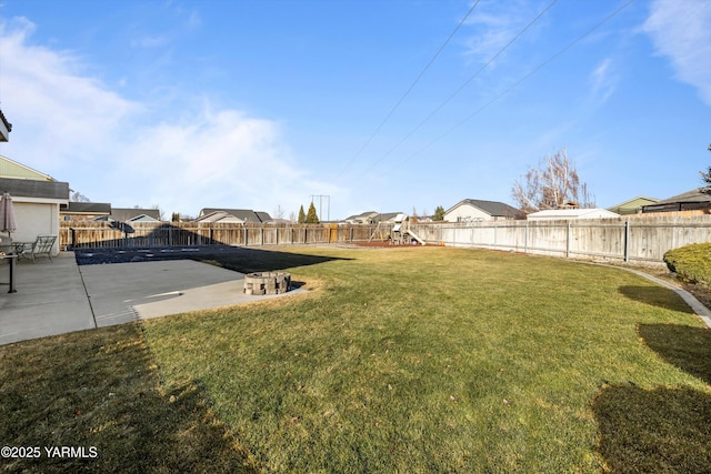 view of yard featuring a patio, a fenced backyard, and a residential view