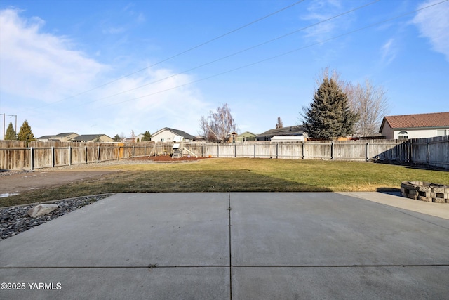 view of yard with a patio area, a fenced backyard, and a residential view