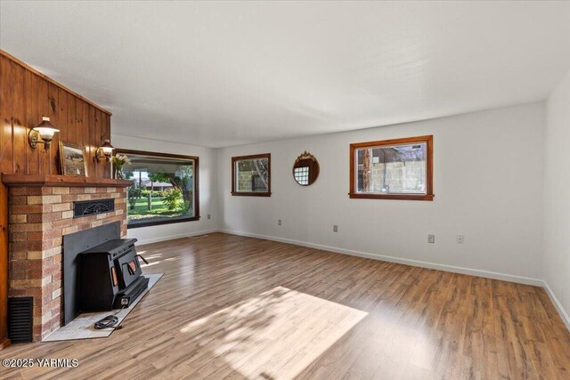 3803 Tieton Dr, Yakima, WA 98902 - unfurnished living room with a wood stove, light wood finished floors, and baseboards