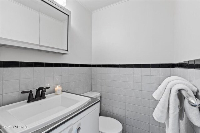 3803 Tieton Dr, Yakima, WA 98902 - bathroom with vanity, tile walls, toilet, ornamental molding, and wainscoting