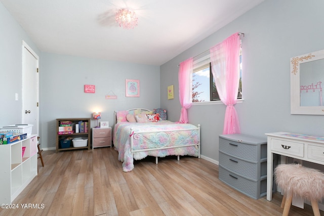 bedroom with light wood-style floors and baseboards