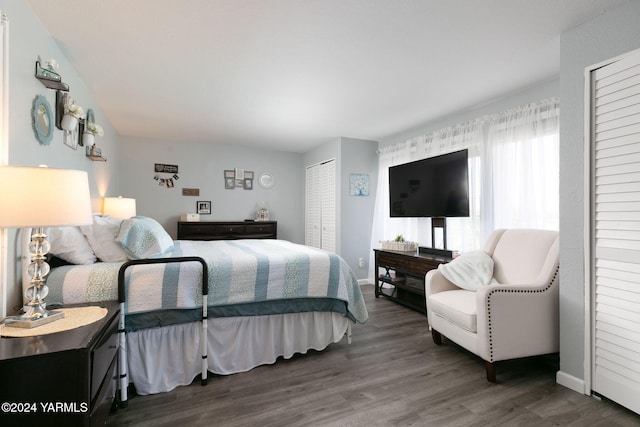 bedroom with dark wood-type flooring and baseboards