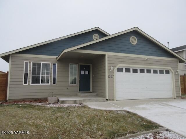 view of front of house with driveway, an attached garage, and fence