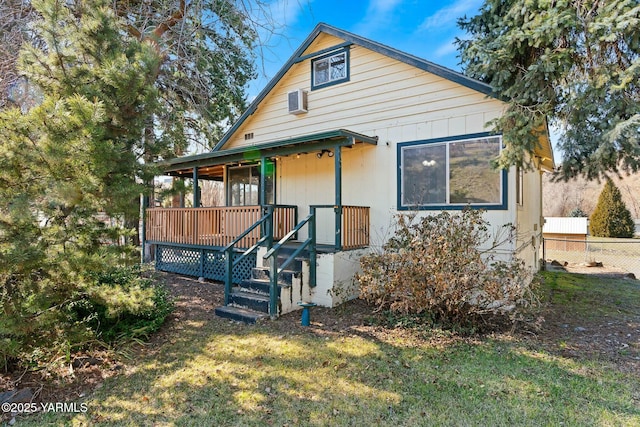 view of front of house with a porch, a front lawn, and fence