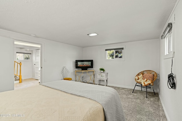 bedroom with baseboards, multiple windows, a textured ceiling, and carpet flooring