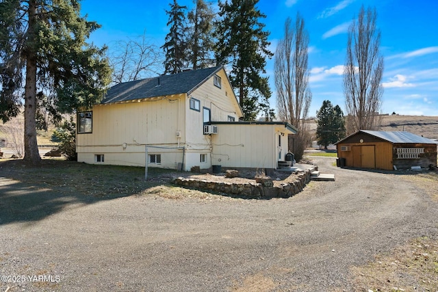 view of side of home featuring cooling unit and a detached garage