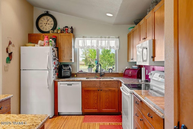 2810 S 79th Ave, Yakima, WA 98903 - kitchen with white appliances, lofted ceiling, light wood-type flooring, light countertops, and brown cabinetry