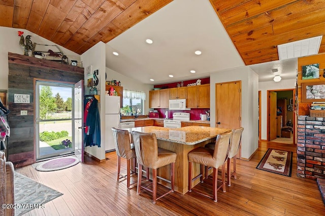 2810 S 79th Ave, Yakima, WA 98903 - kitchen featuring white appliances, lofted ceiling, light wood-style flooring, a breakfast bar, and a center island