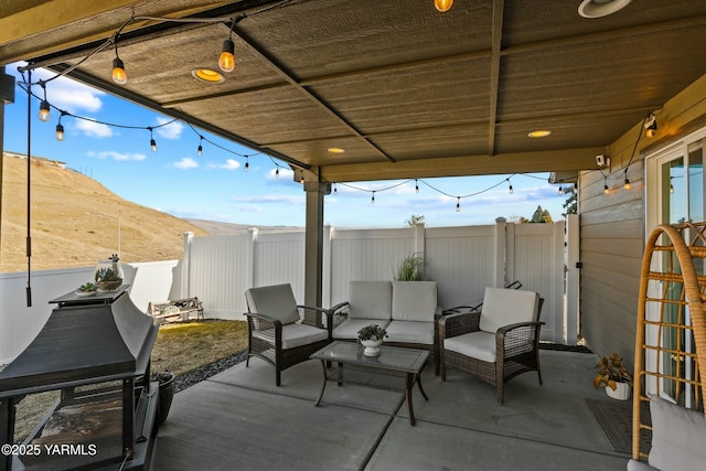 view of patio / terrace with an outdoor living space, a fenced backyard, and a mountain view