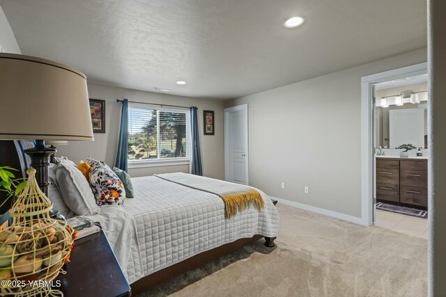 bedroom featuring recessed lighting, light colored carpet, visible vents, baseboards, and ensuite bath