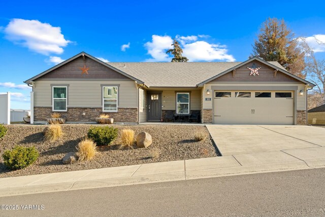 view of front of property featuring stone siding, concrete driveway, and an attached garage