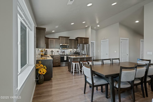 dining area with lofted ceiling, visible vents, light wood-style flooring, and recessed lighting