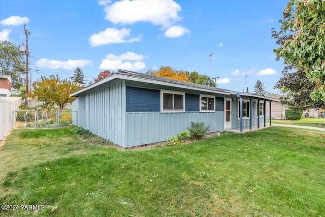 ranch-style house with fence, a front lawn, and board and batten siding