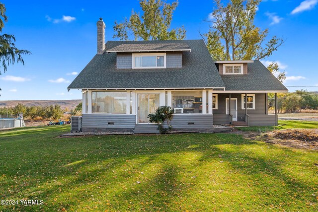 view of front of home with a chimney, roof with shingles, crawl space, and a front yard