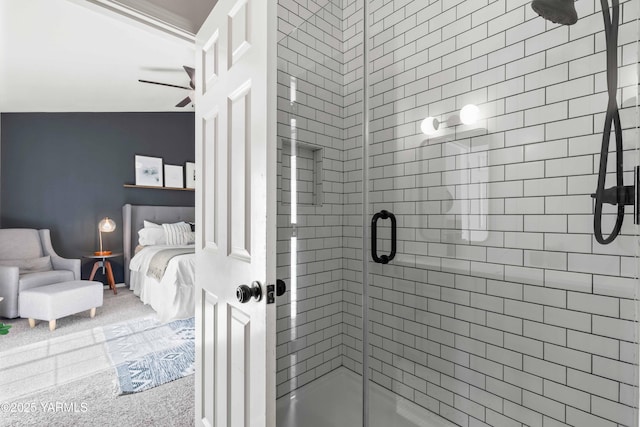 ensuite bathroom featuring connected bathroom, ceiling fan, and a stall shower