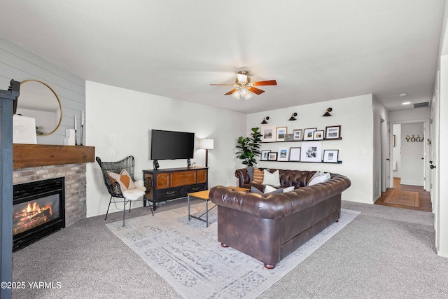 carpeted living room featuring visible vents, a brick fireplace, and ceiling fan