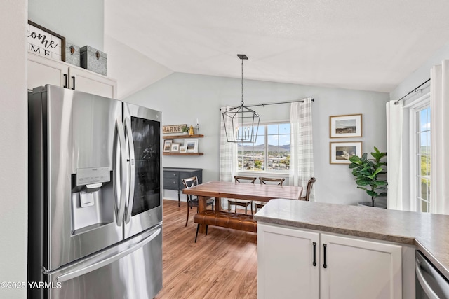 kitchen with light wood-type flooring, white cabinets, lofted ceiling, stainless steel appliances, and a wealth of natural light