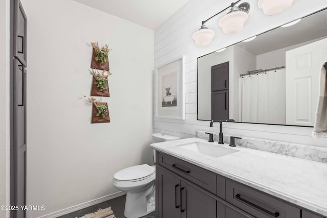 bathroom featuring vanity, tile patterned flooring, and toilet