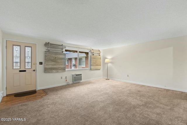 unfurnished living room featuring carpet, baseboards, a textured ceiling, and a wall mounted air conditioner