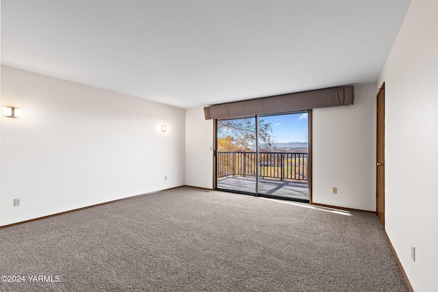 carpeted spare room featuring baseboards