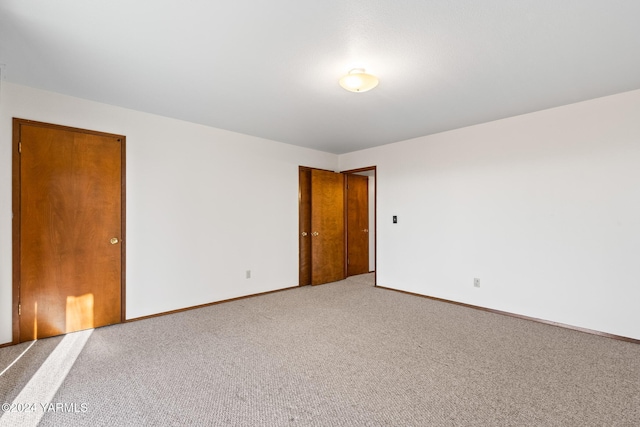 unfurnished room featuring carpet floors and baseboards