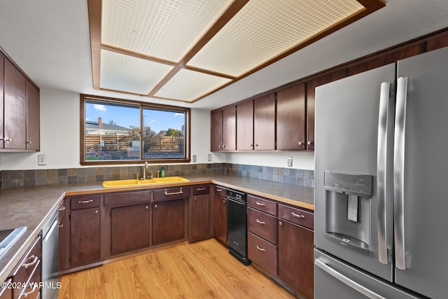 kitchen featuring light wood finished floors, dark brown cabinets, appliances with stainless steel finishes, and a sink