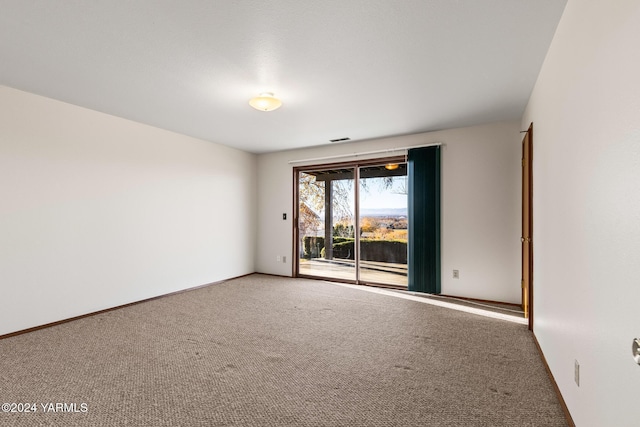 carpeted empty room featuring visible vents and baseboards