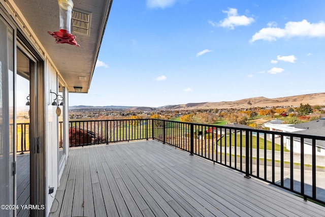 wooden deck featuring visible vents and a mountain view