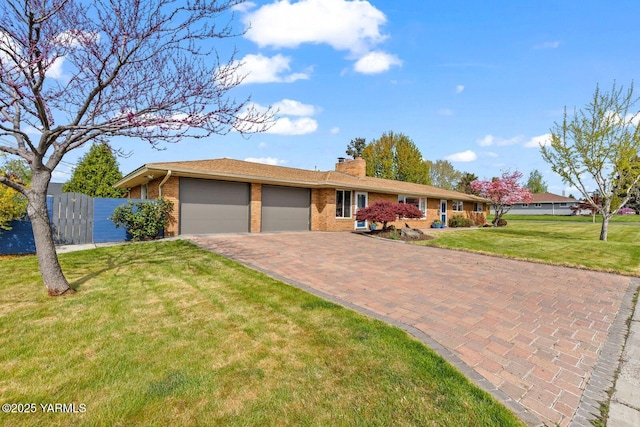 220 N 42nd Ave, Yakima, WA 98908 - ranch-style house featuring a chimney, decorative driveway, brick siding, a front yard, and a garage
