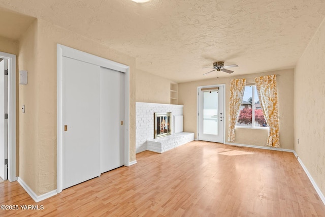 220 N 42nd Ave, Yakima, WA 98908 - unfurnished living room featuring ceiling fan, light wood-style floors, a textured ceiling, and a fireplace