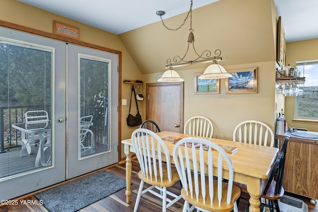 dining space featuring vaulted ceiling, wood finished floors, and french doors