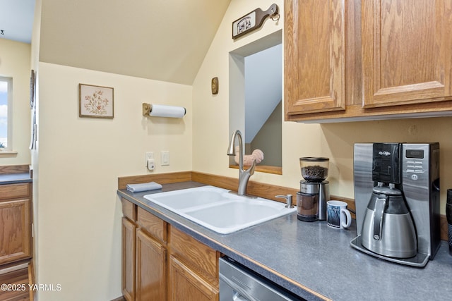 kitchen featuring dark countertops, brown cabinets, a sink, and stainless steel dishwasher