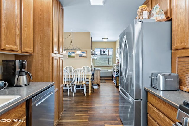 kitchen featuring brown cabinets, dark wood-style floors, and stainless steel appliances