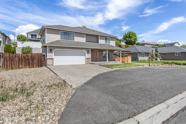 7511 Maclaren St, Yakima, WA 98908 - traditional-style home featuring brick siding, driveway, fence, an attached garage, and a residential view