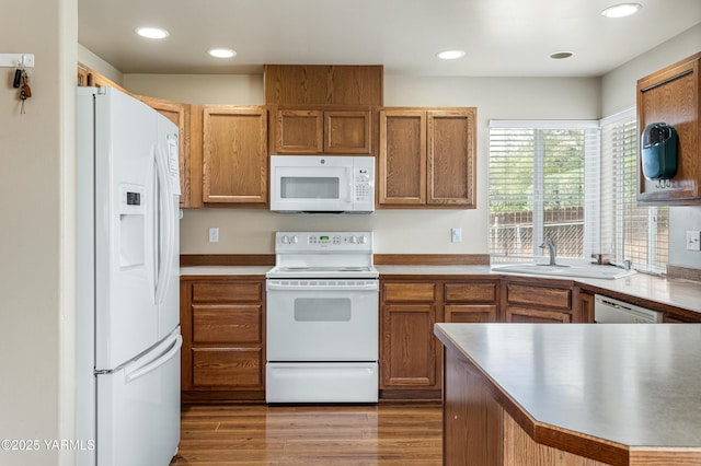 7511 Maclaren St, Yakima, WA 98908 - kitchen with white appliances, a sink, brown cabinetry, recessed lighting, and wood finished floors