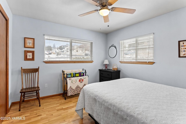 bedroom featuring a ceiling fan, a closet, baseboards, and wood finished floors