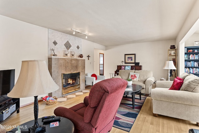 living area with wood finished floors and a tile fireplace