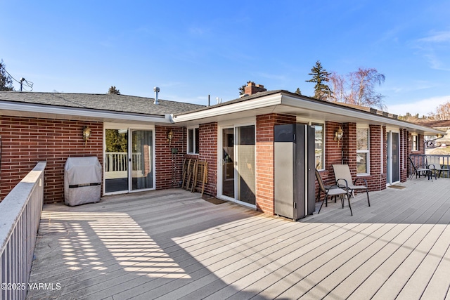 wooden terrace featuring a grill