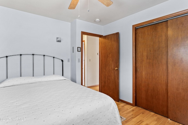 bedroom featuring ceiling fan, a closet, light wood-type flooring, and baseboards
