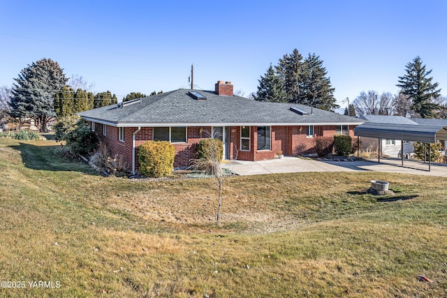 rear view of house with a chimney, a lawn, and brick siding