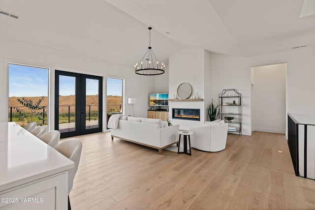 4611 Hilltop Way, Yakima, WA 98908 - living room with french doors, light wood finished floors, a chandelier, high vaulted ceiling, and a fireplace